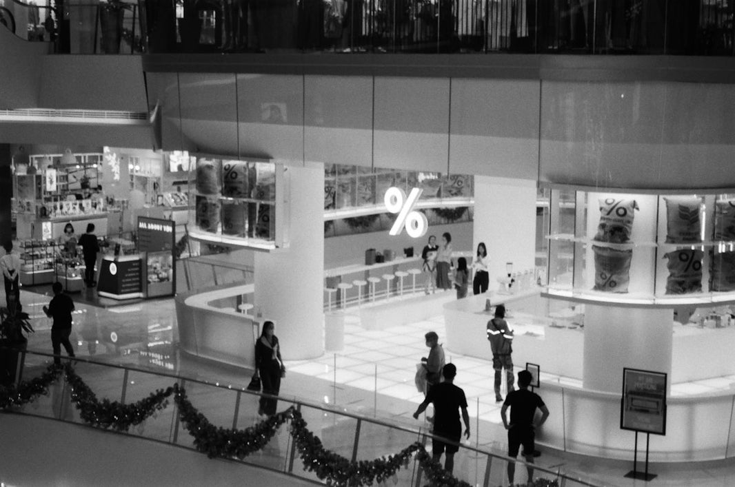 people walking inside building in grayscale photography