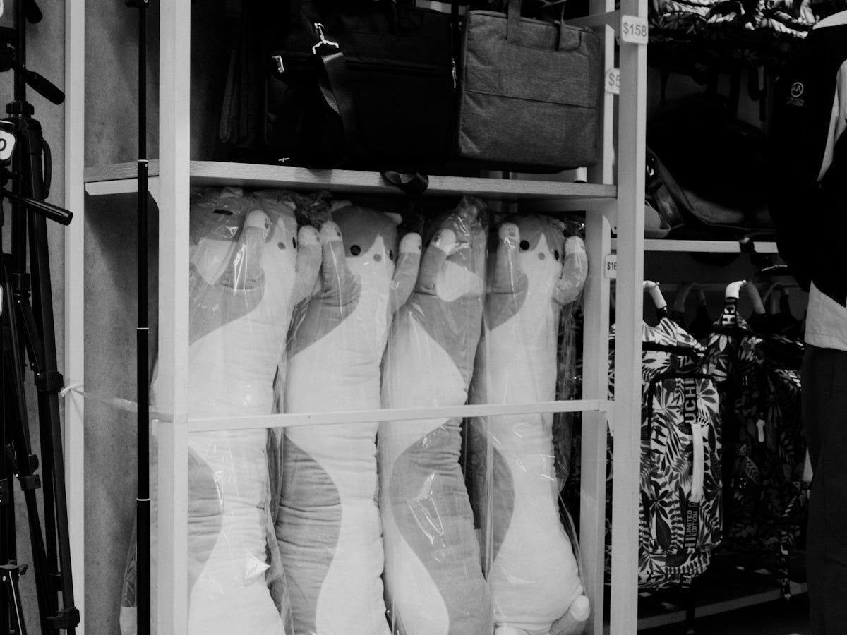 black and white photograph of a person standing in front of a rack of shoes
