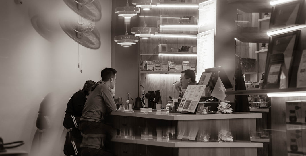People at a counter in a modern cafe.