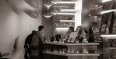 People at a counter in a modern cafe.